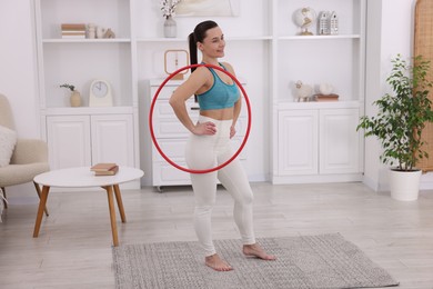 Photo of Smiling woman with hula hoop at home