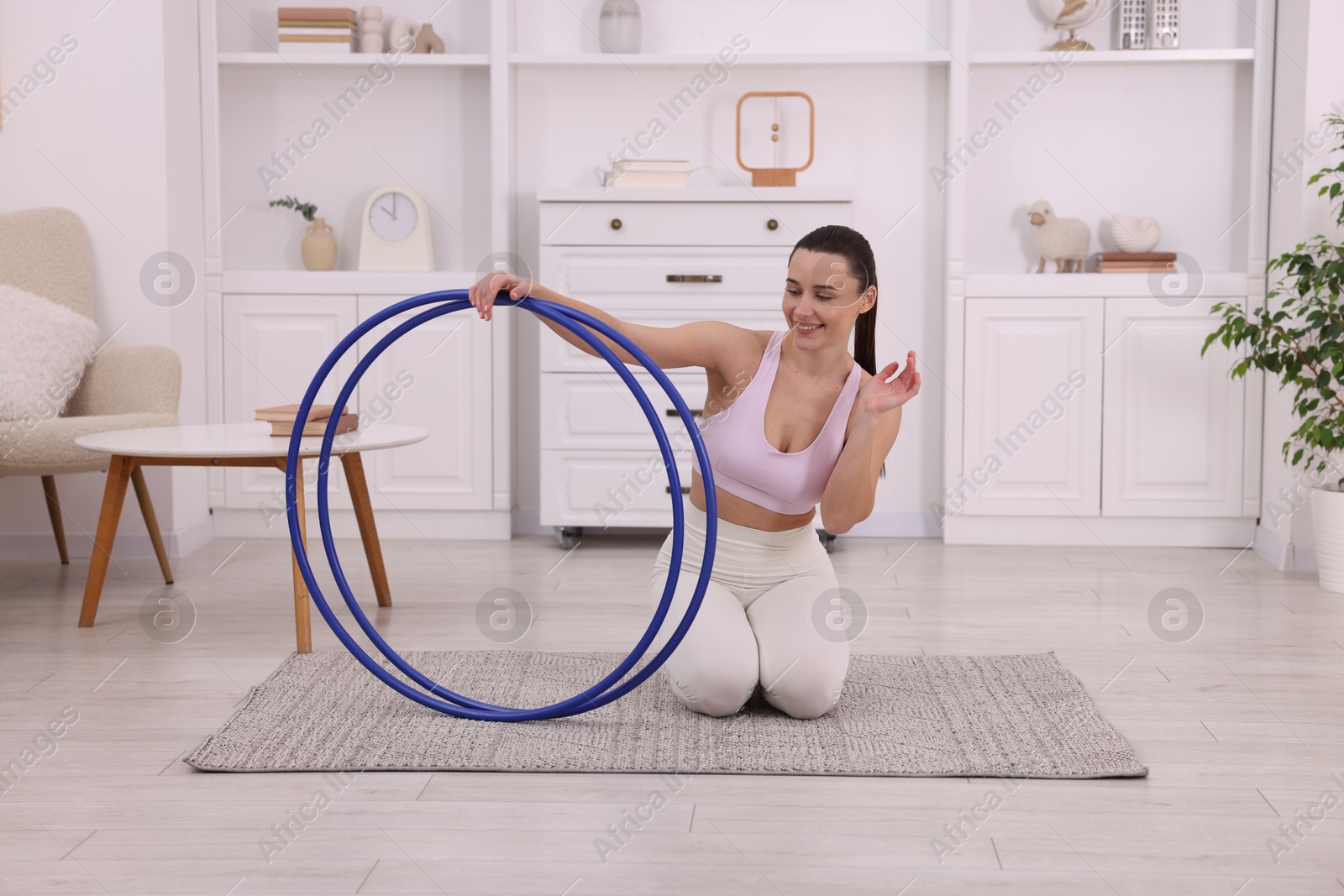 Photo of Smiling woman with hula hoops at home