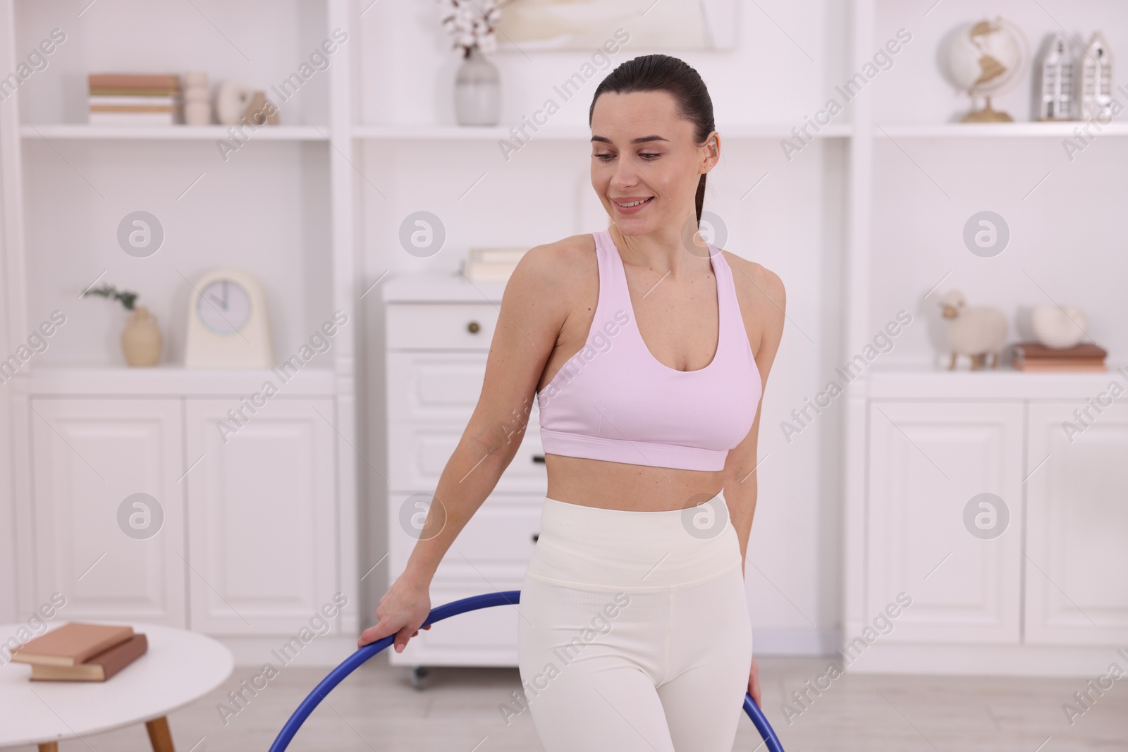 Photo of Smiling woman with hula hoop at home