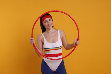 Photo of Smiling woman with hula hoop on orange background