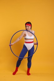 Photo of Beautiful woman with hula hoop on orange background