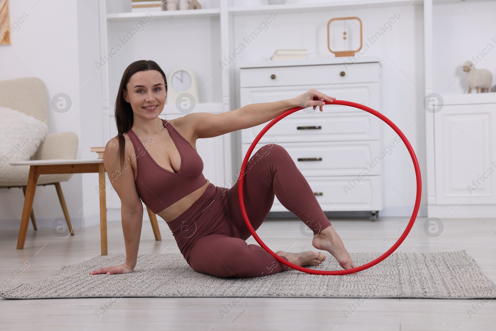 Photo of Smiling woman with hula hoop at home