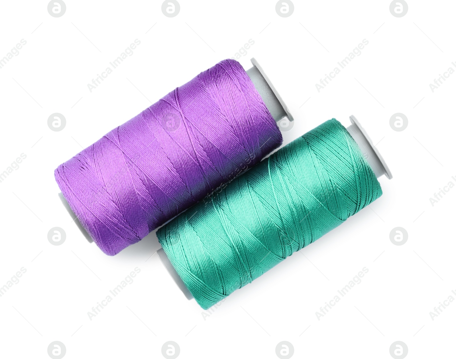 Photo of Spools of bright sewing threads isolated on white, top view