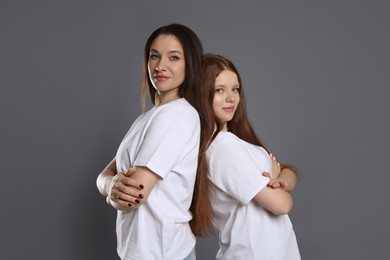 Photo of Portrait of beautiful mother with teenage daughter on grey background