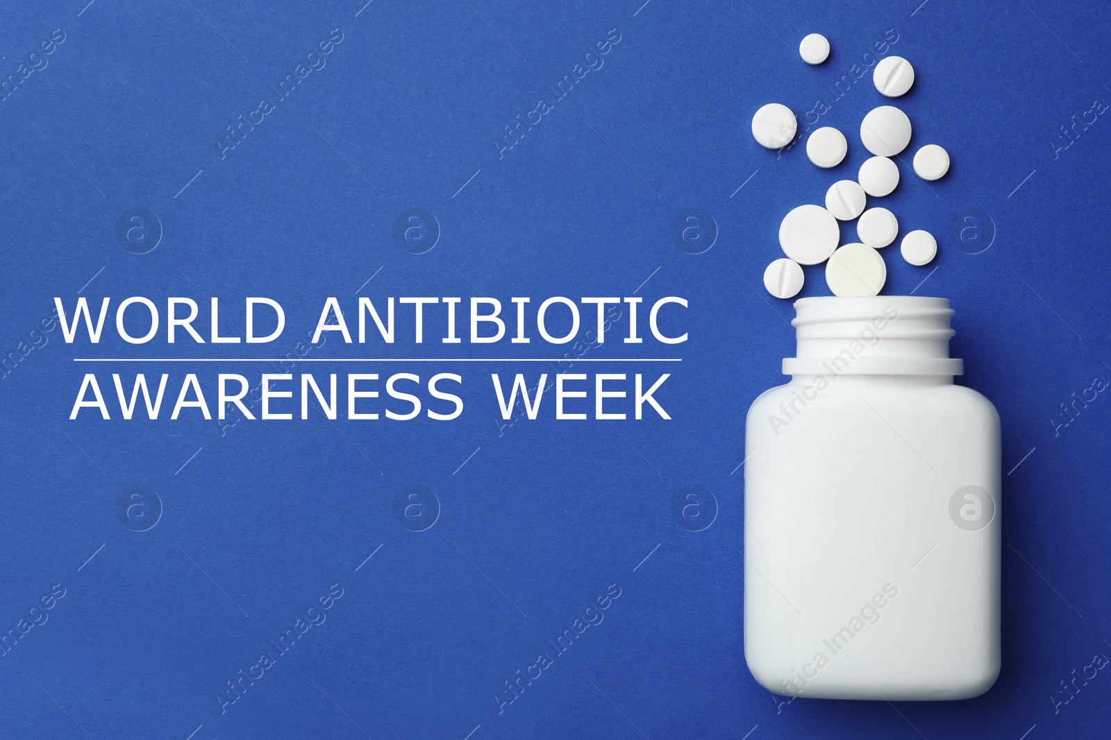 Image of World antibiotic awareness week. Bottle and scattered pills on blue background, top view