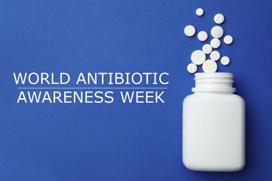 Image of World antibiotic awareness week. Bottle and scattered pills on blue background, top view