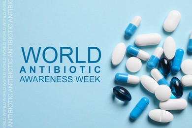 Image of World antibiotic awareness week. Many different pills on light blue background, flat lay