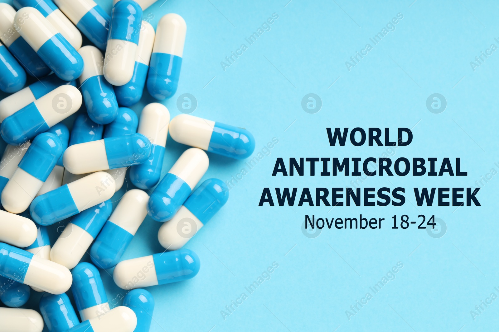 Image of World antimicrobial awareness week. Many pills on light blue background, flat lay