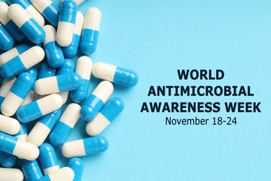 Image of World antimicrobial awareness week. Many pills on light blue background, flat lay