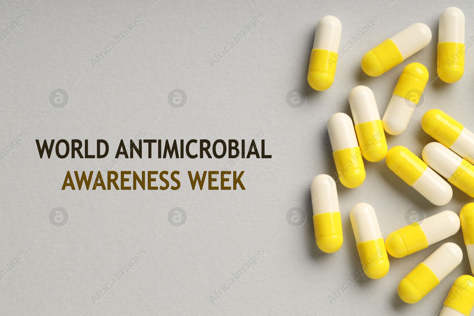 Image of World antimicrobial awareness week. Many pills on grey background, flat lay