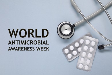 Image of World antimicrobial awareness week. PIlls and stethoscope on grey background, flat lay