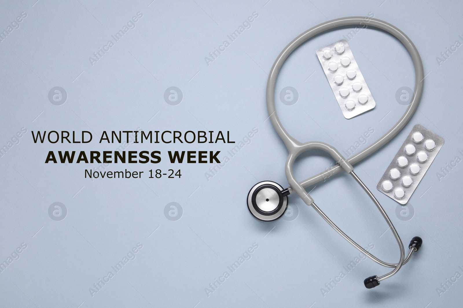 Image of World antimicrobial awareness week. PIlls and stethoscope on grey background, flat lay