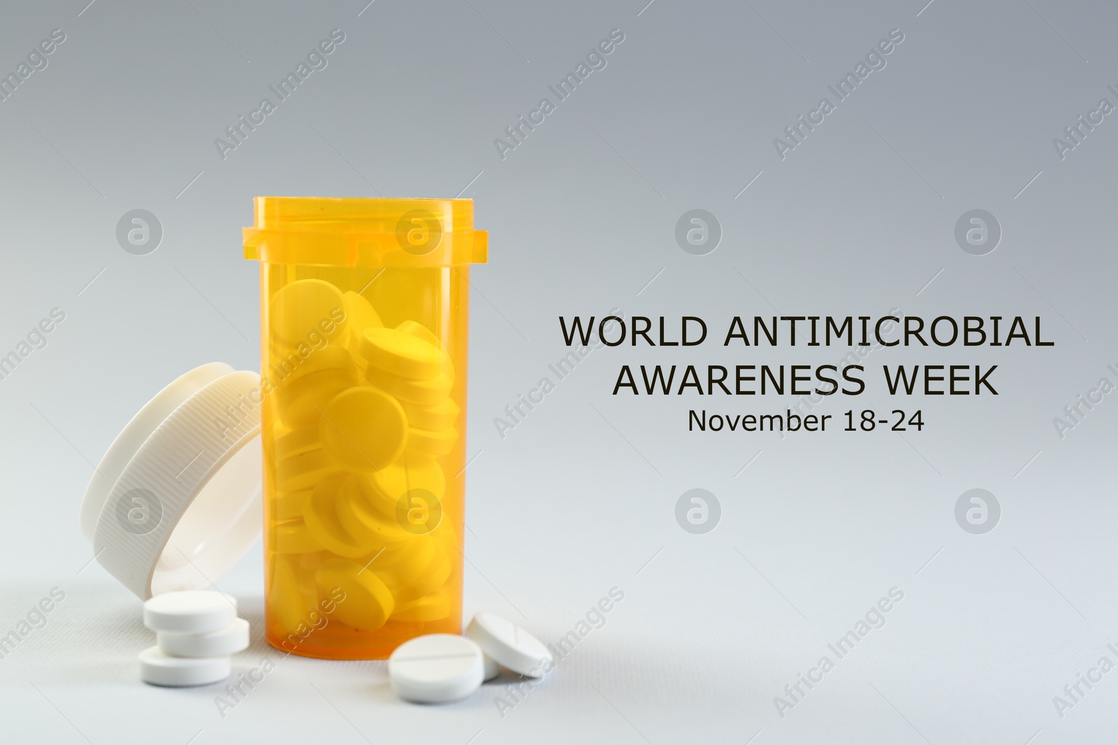 Image of World antimicrobial awareness week. Bottle and scattered pills on grey background