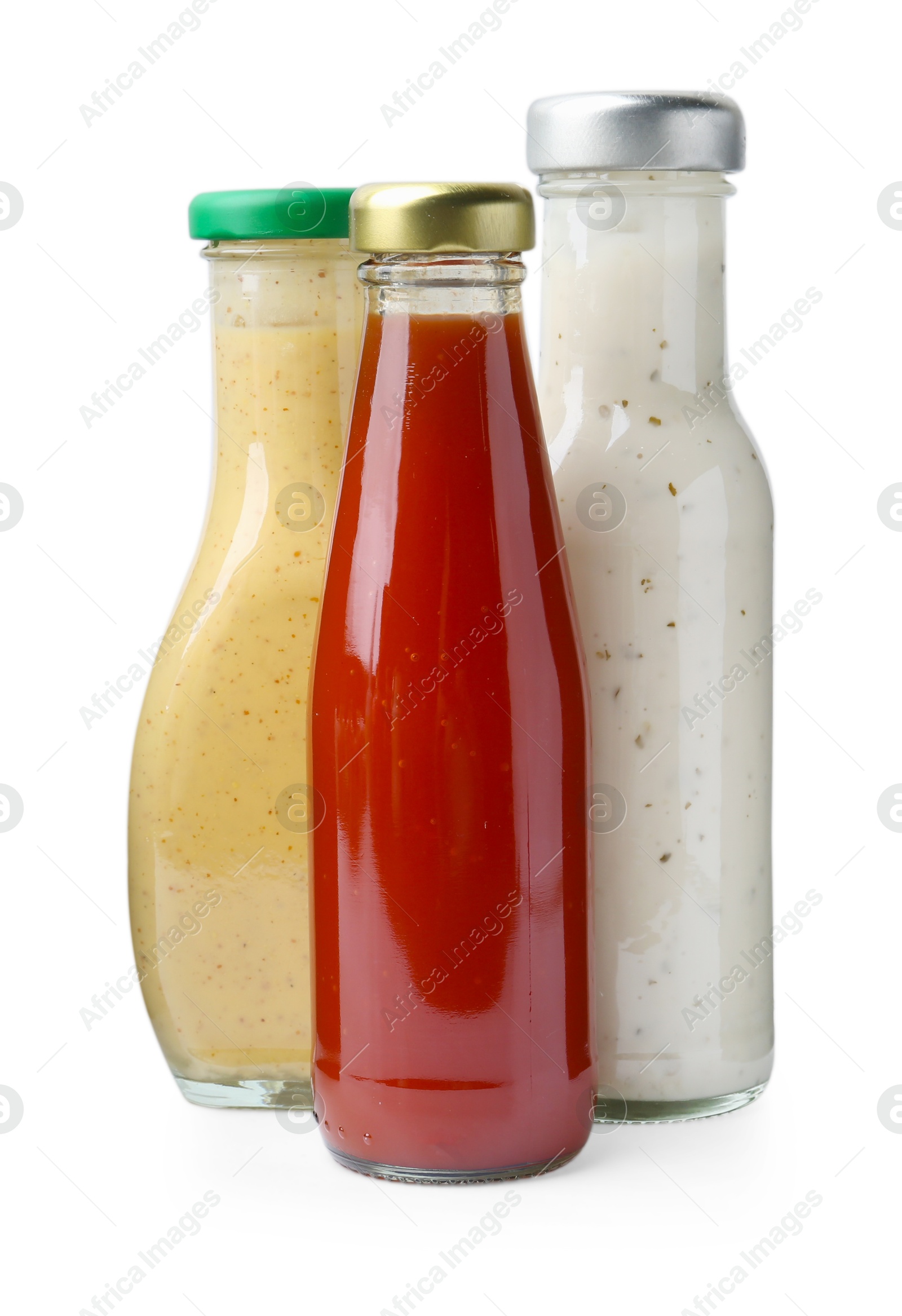 Photo of Different delicious sauces in glass bottles isolated on white