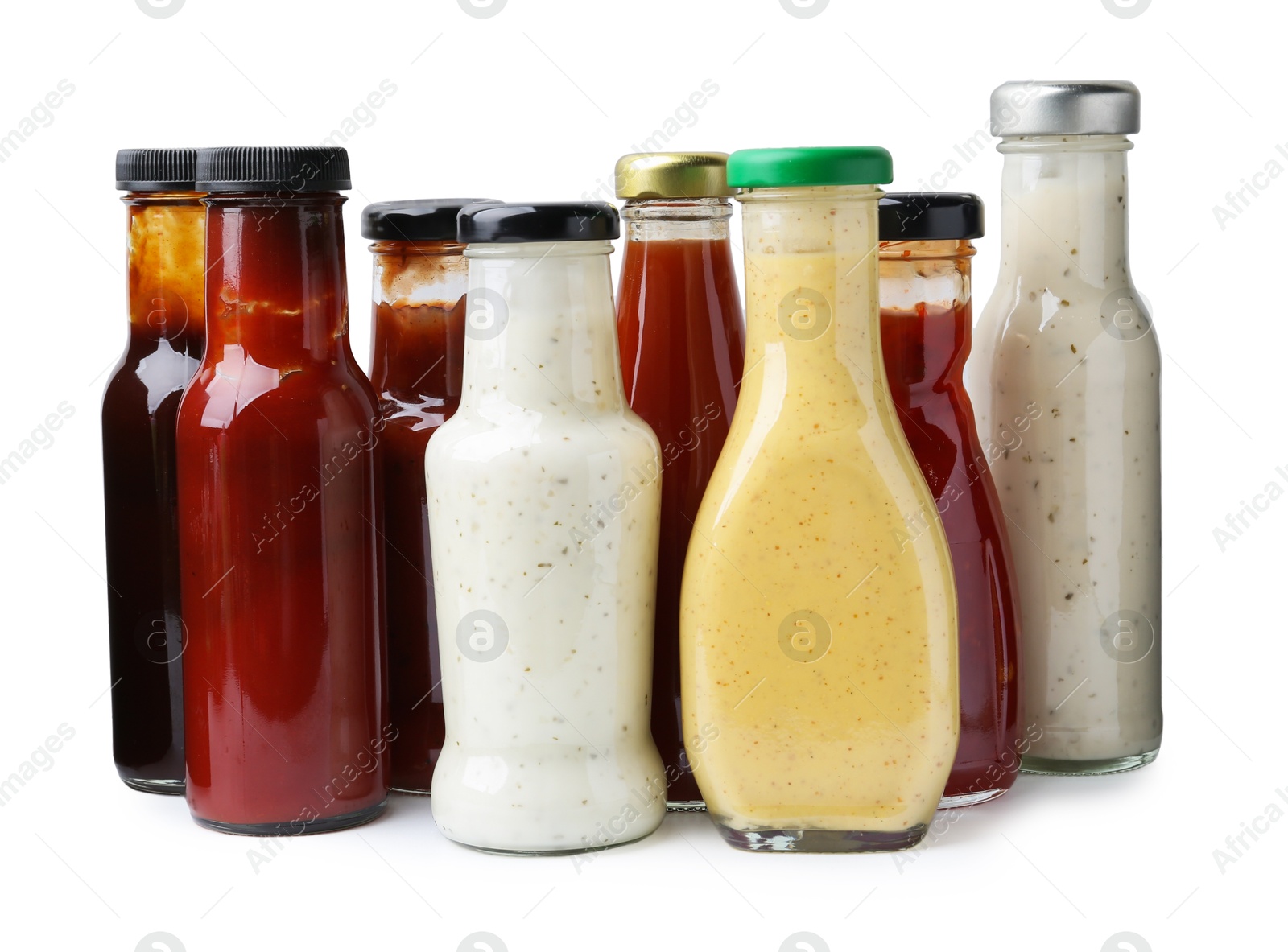 Photo of Different delicious sauces in glass bottles isolated on white