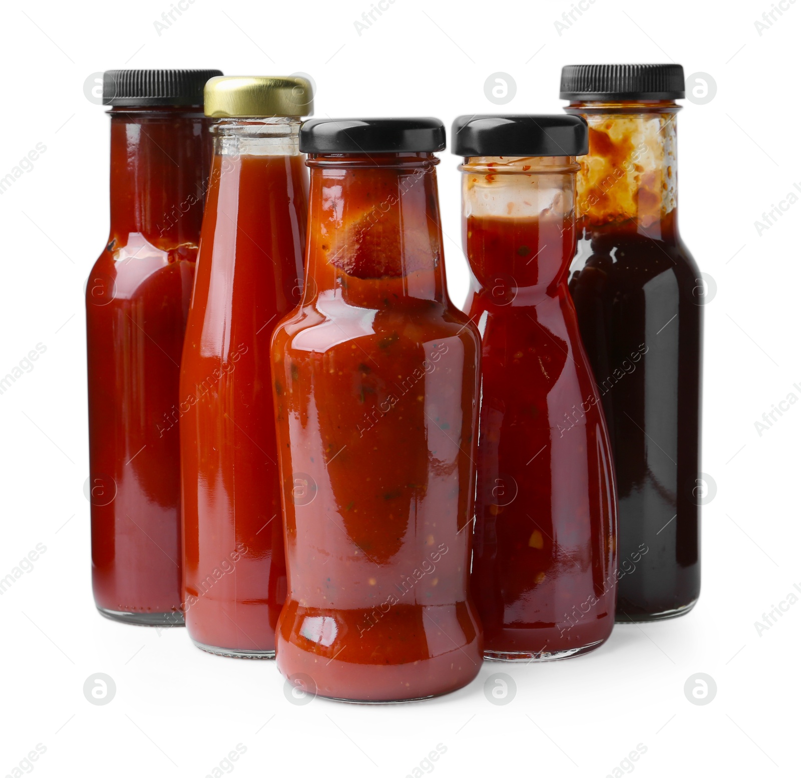 Photo of Different delicious sauces in glass bottles isolated on white