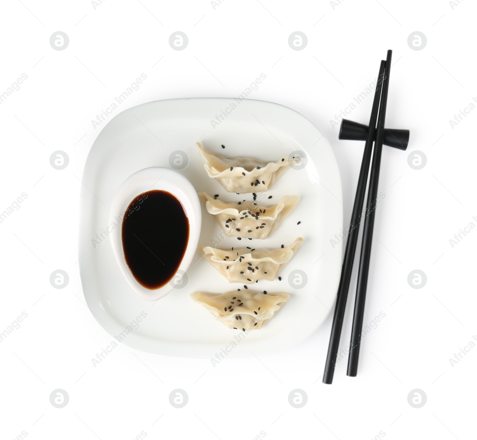 Photo of Tasty gyoza (dumplings), soy sauce and chopsticks isolated on white, top view