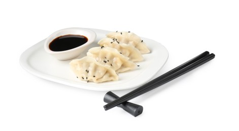 Photo of Tasty gyoza (dumplings), soy sauce and chopsticks isolated on white