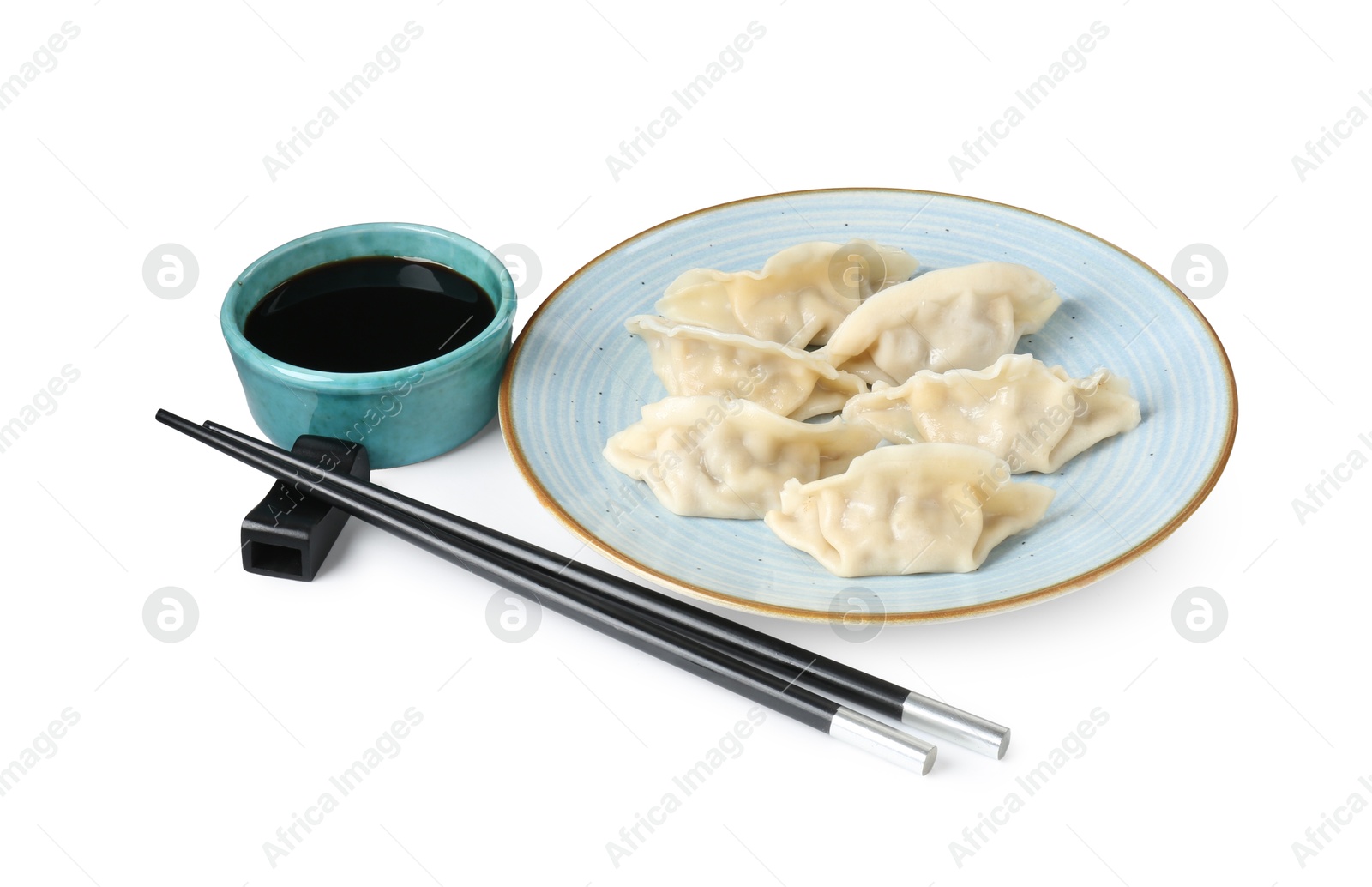 Photo of Tasty gyoza (dumplings), soy sauce and chopsticks isolated on white