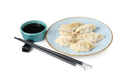 Photo of Tasty gyoza (dumplings), soy sauce and chopsticks isolated on white