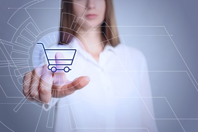 Image of Online store. Woman touching shopping cart icon on virtual screen against grey background, closeup