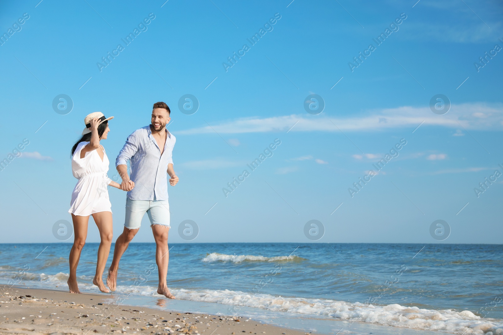 Photo of Happy young couple running together on beach