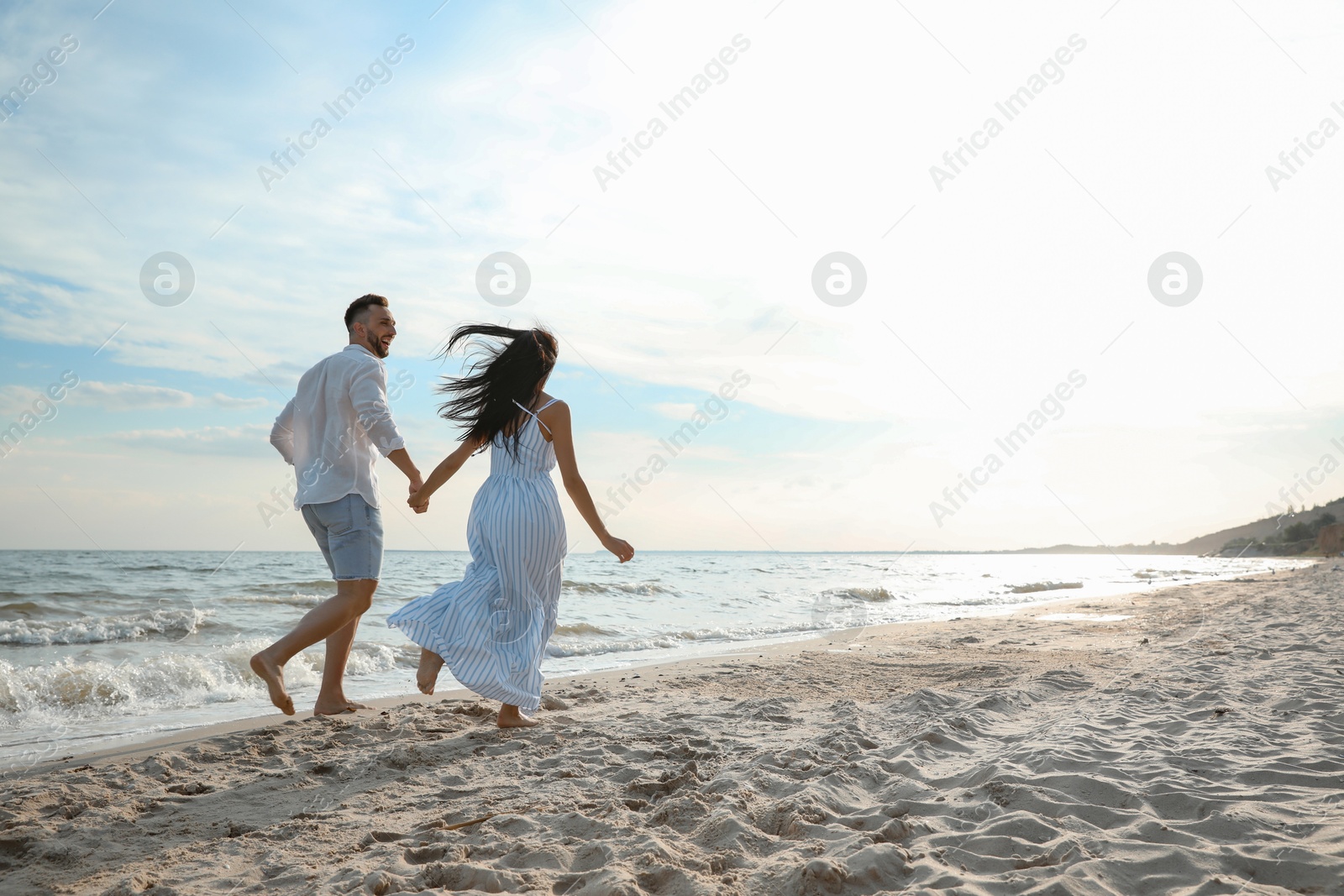 Photo of Happy young couple running together on beach