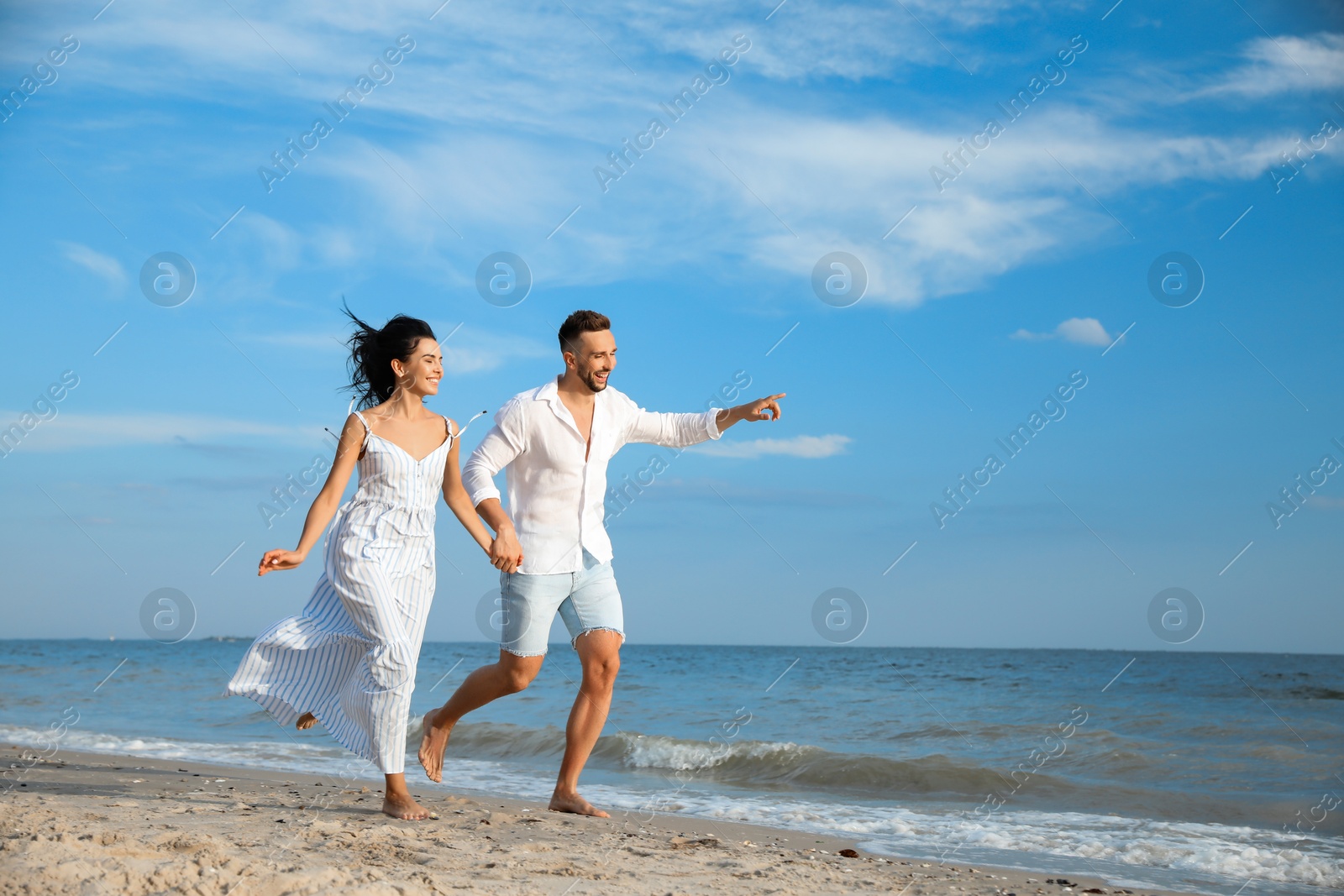 Photo of Happy young couple running together on beach