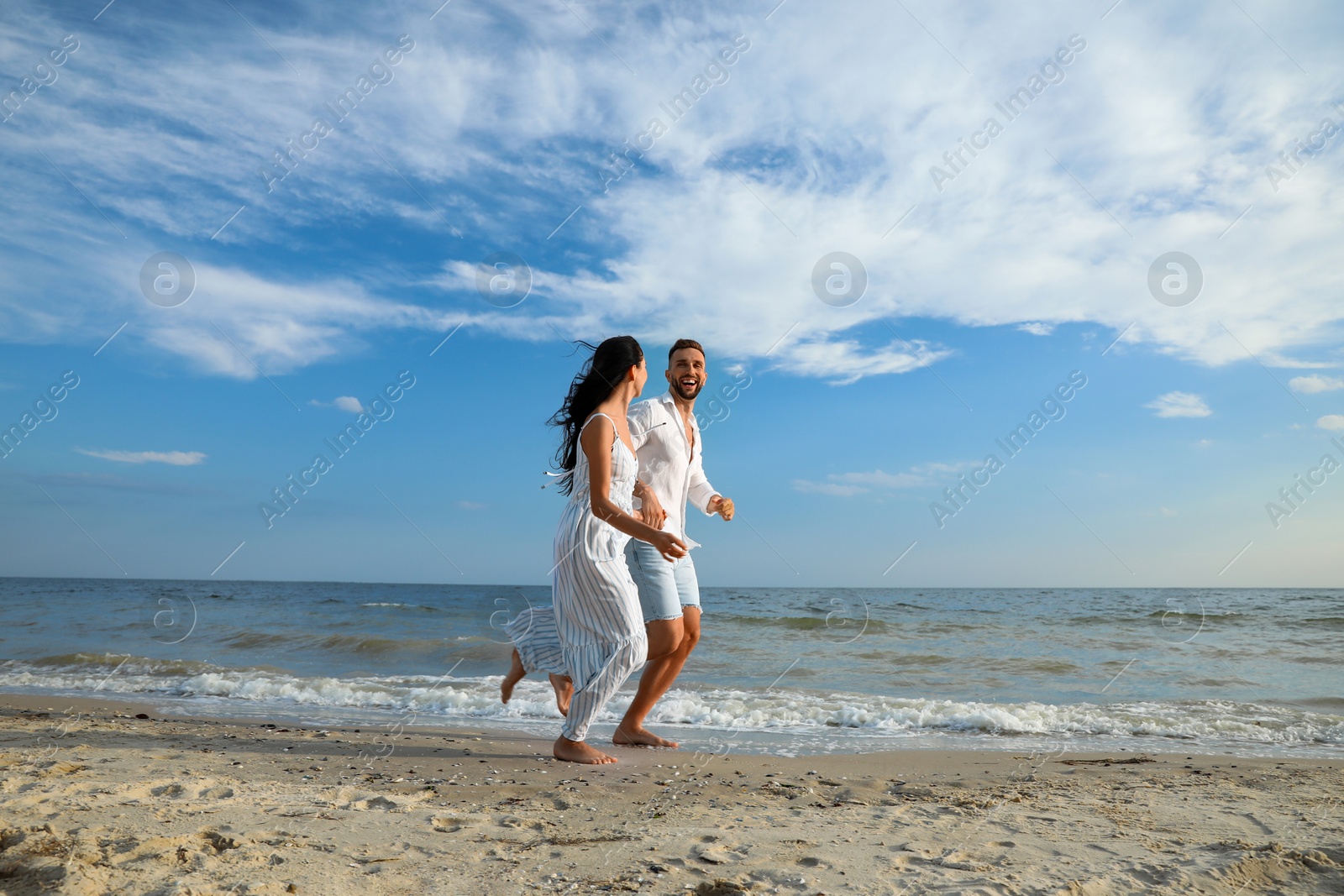 Photo of Happy young couple running together on beach