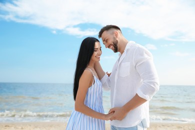 Photo of Happy young couple at beach on sunny day