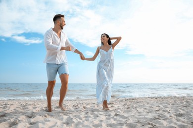 Photo of Happy young couple running together on beach