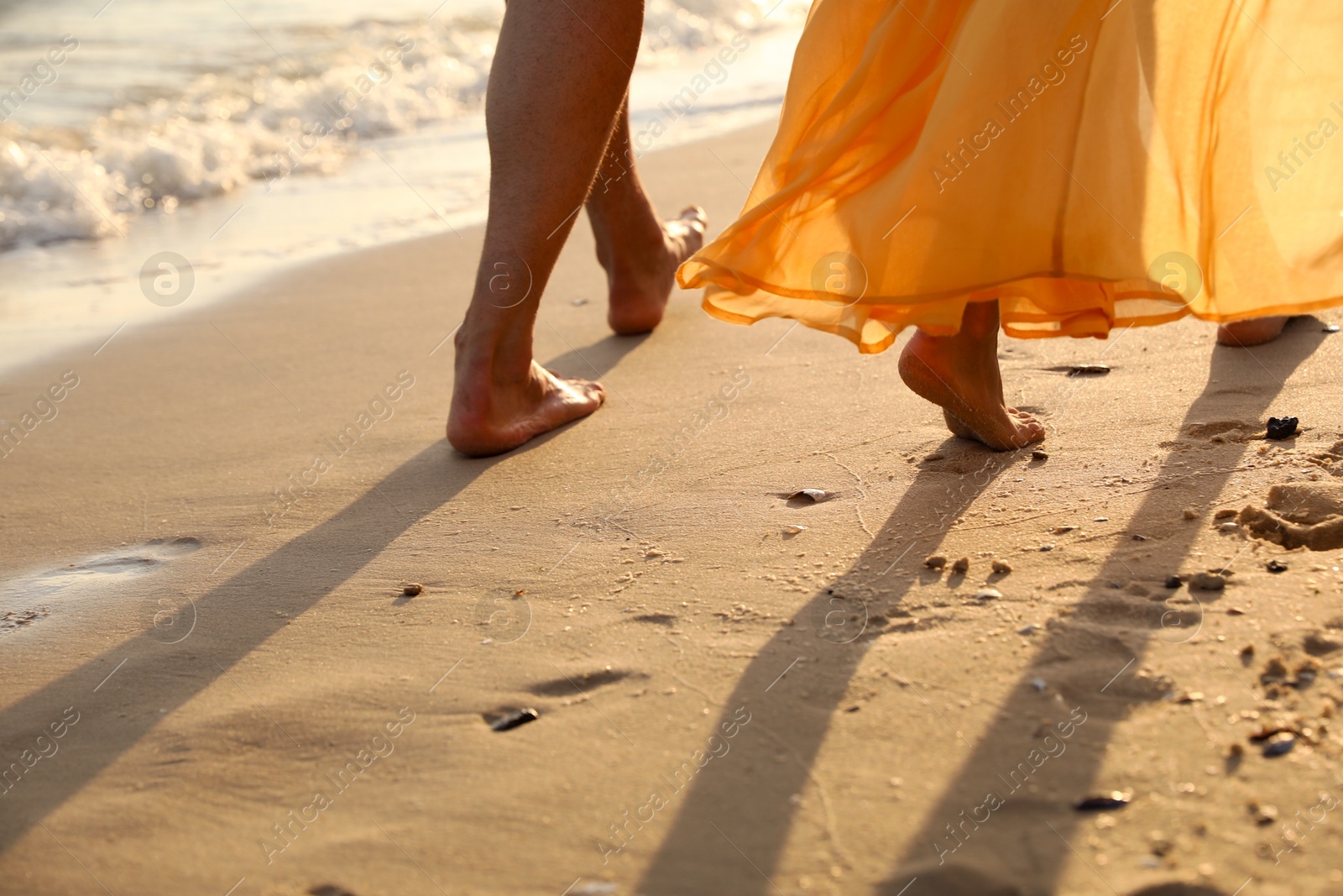 Photo of Couple walking together on beach, closeup view