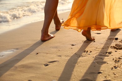 Photo of Couple walking together on beach, closeup view