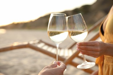 Photo of Romantic couple drinking wine together on beach, closeup