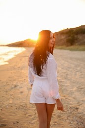 Photo of Young beautiful woman on beach at sunset