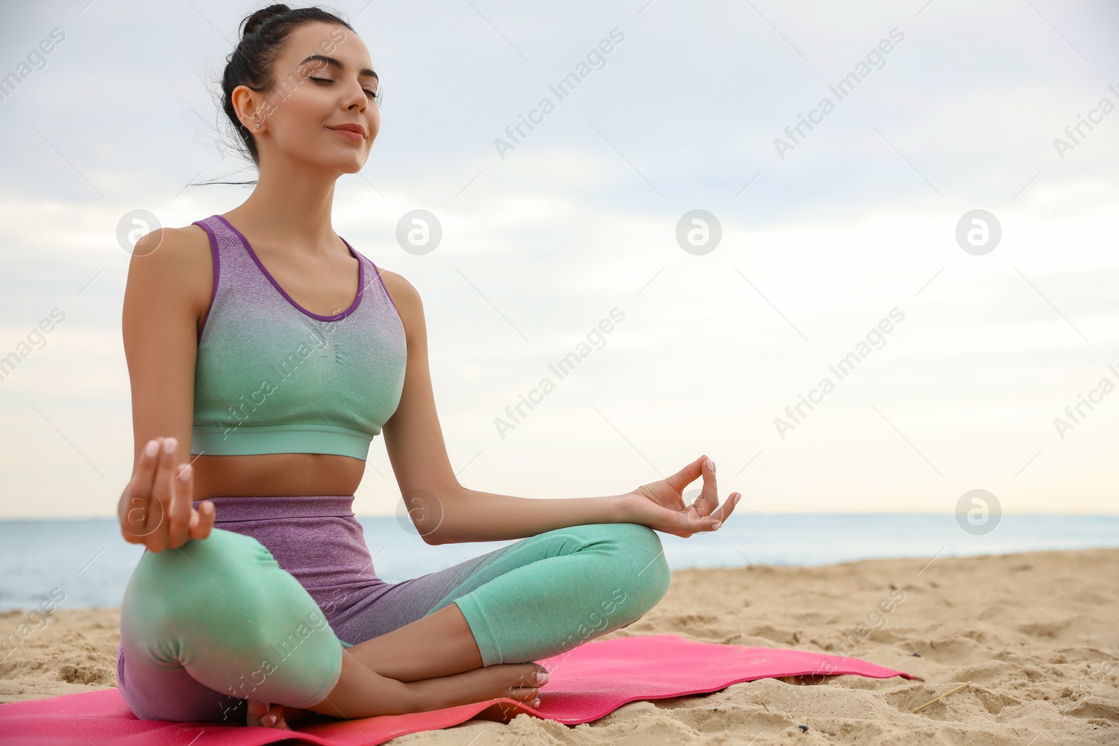 Photo of Young woman practicing yoga on beach, space for text. Body training