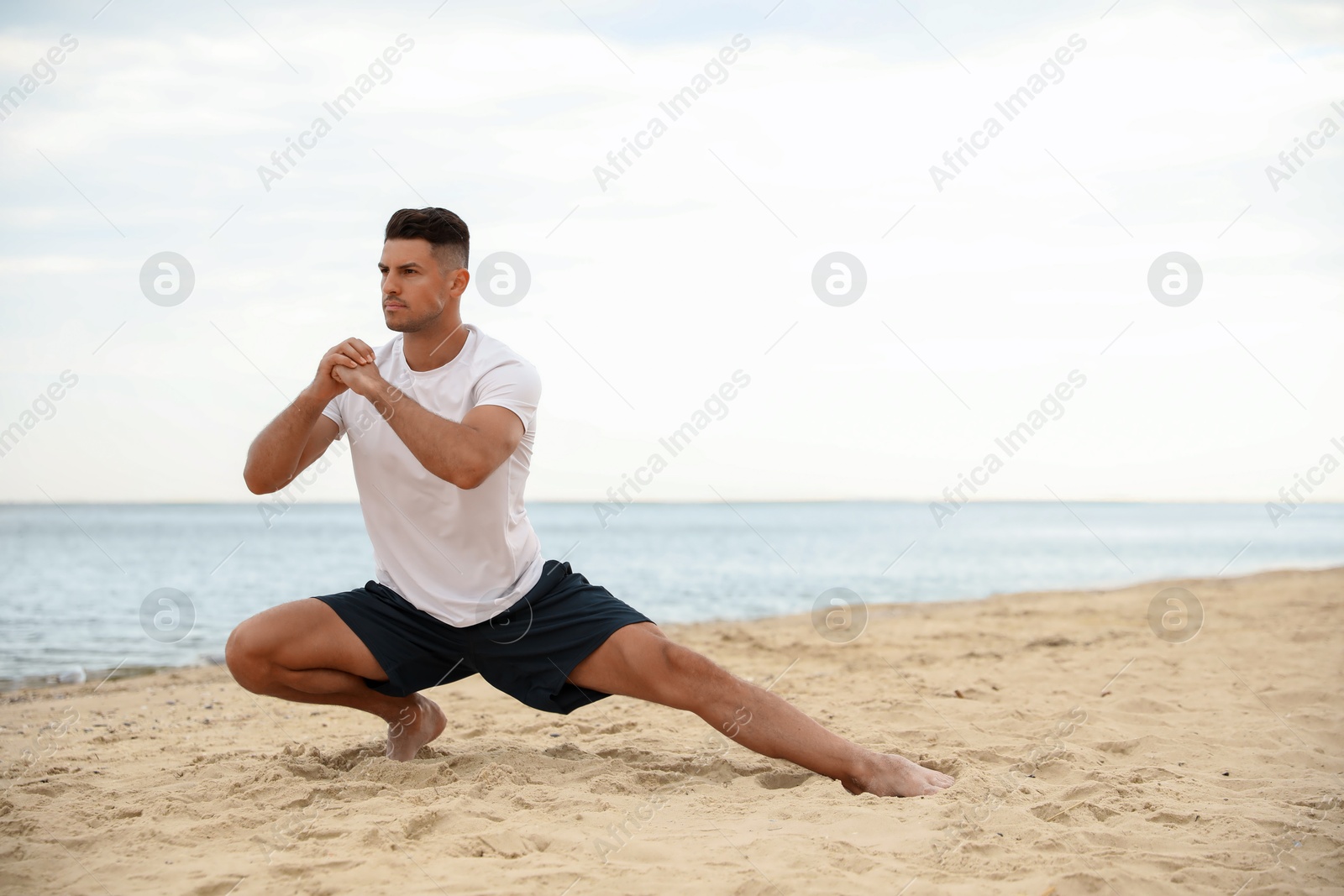 Photo of Muscular man doing exercise on beach, space for text. Body training