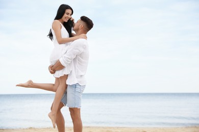 Photo of Lovely couple having fun on beautiful beach. Space for text