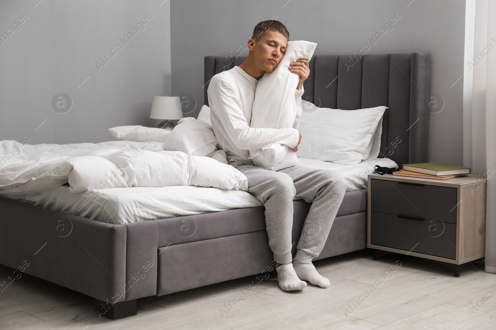 Photo of Young man suffering from sleepwalking on bed at home