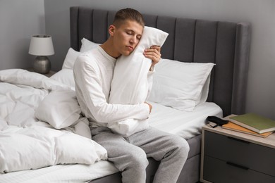 Photo of Young man suffering from sleepwalking on bed at home