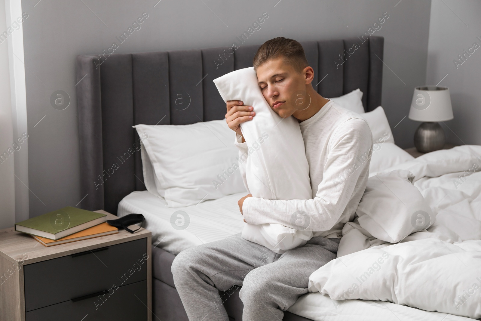 Photo of Young man suffering from sleepwalking on bed at home