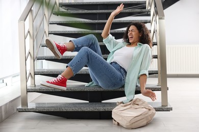 Photo of Injured woman on stairs in building after fall. Dangerous accident