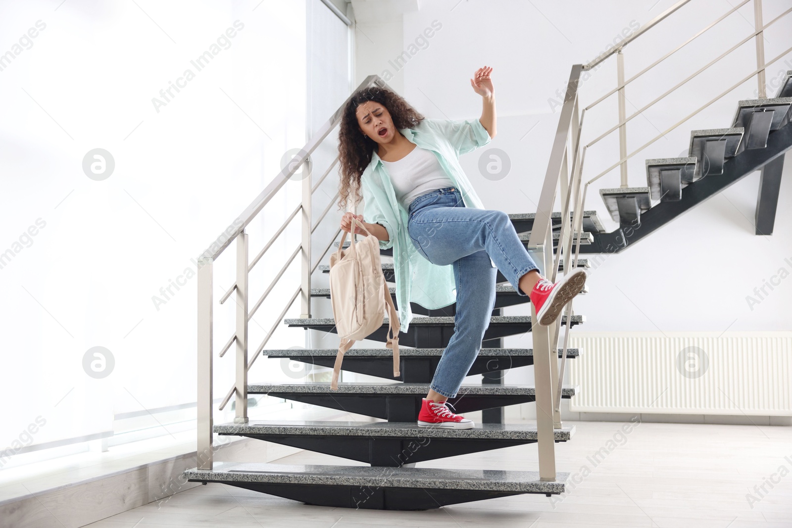 Photo of Woman falling on stairs in building. Dangerous accident