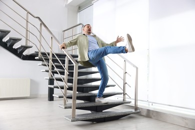 Photo of Man falling on stairs in building. Dangerous accident