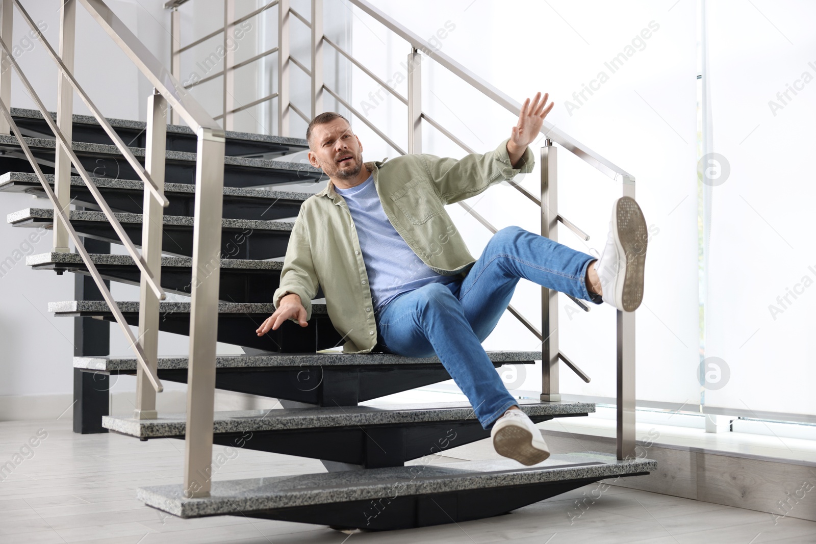 Photo of Man falling on stairs in building. Dangerous accident