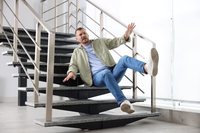 Photo of Man falling on stairs in building. Dangerous accident