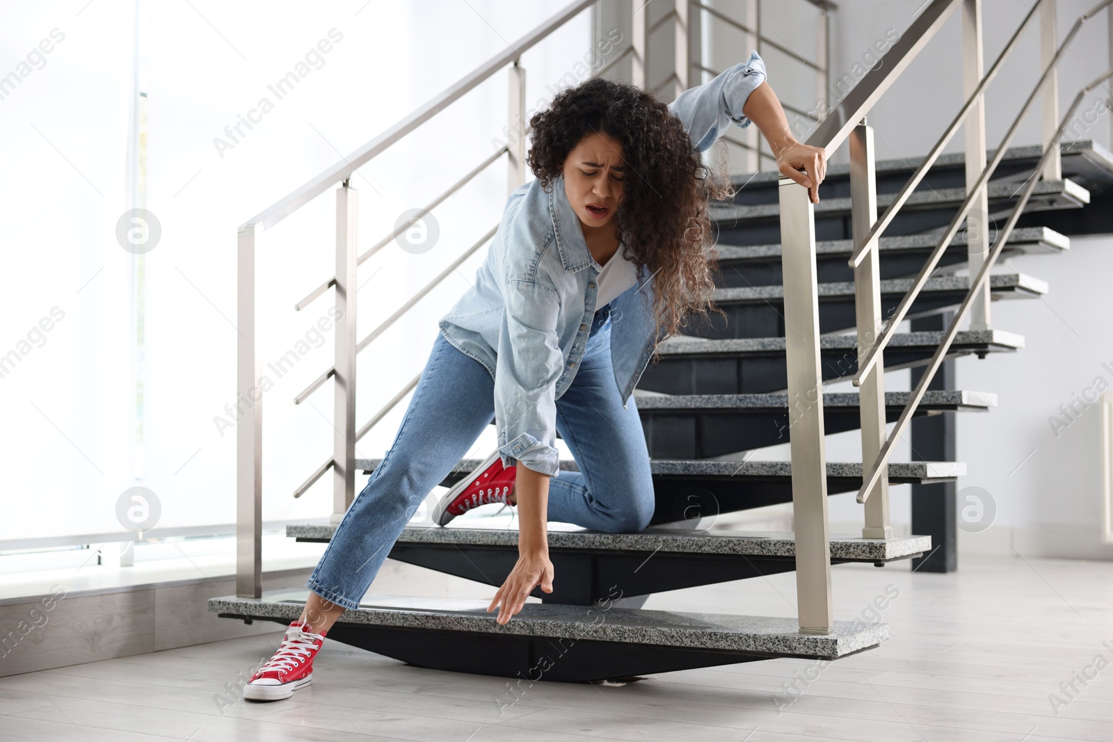 Photo of Woman falling on stairs in building. Dangerous accident