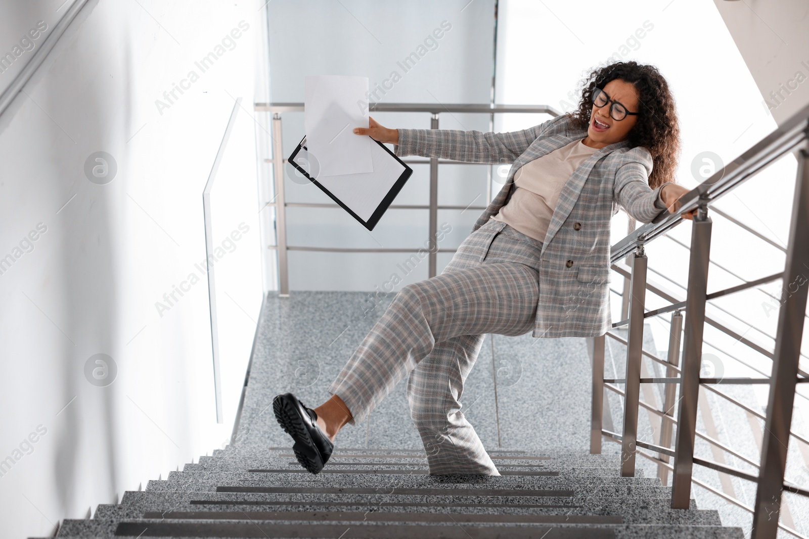 Photo of Woman falling on stairs in building. Dangerous accident