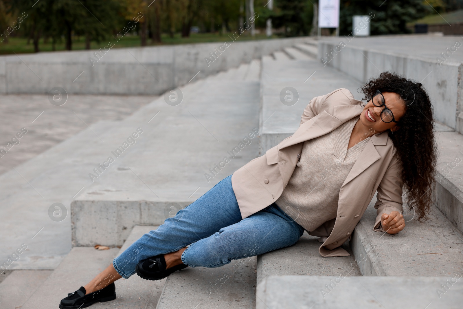 Photo of Injured woman on stairs outdoors after fall. Dangerous accident