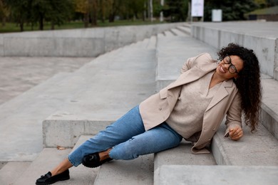 Photo of Injured woman on stairs outdoors after fall. Dangerous accident